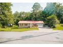 Quaint brick home with a red metal roof, front porch, and a well-maintained lawn at 4565 Deerfield Dr, Cumming, GA 30028