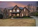 Inviting brick home with red shutters, professional landscaping, and an American flag at 6350 Old Wood Hollow Way, Buford, GA 30518