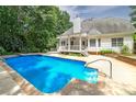 Inviting backyard oasis featuring a sparkling blue pool and covered patio, perfect for relaxation at 90 Barrington Grange Dr, Sharpsburg, GA 30277