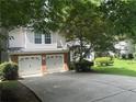 Two-story home with a brick-and-vinyl facade, two-car garage, and concrete driveway at 1035 Towne Manor Nw Ct, Kennesaw, GA 30144