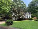 Inviting two-story home nestled among mature trees on a lush green lawn at 1035 Towne Manor Nw Ct, Kennesaw, GA 30144