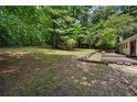 Spacious and private backyard surrounded by mature trees, featuring a deck and room to enjoy at 1729 Norden Rd, Riverdale, GA 30296