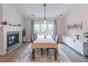 Dining room features fireplace, modern buffet, and large windows overlooking backyard at 220 Chandler Ct, Sugar Hill, GA 30518