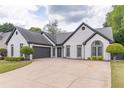 Charming brick home features a well-manicured lawn and a driveway at 220 Chandler Ct, Sugar Hill, GA 30518