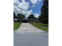 Charming single-story brick home with a long driveway and attached carport, nestled among mature trees at 6192 Meadowbrook Dr, Norcross, GA 30093