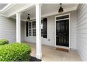 Inviting front porch with black door, 'welcome' mat, white columns, and detailed trim at 21 Spring Folly Nw, Cartersville, GA 30121