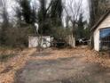 Backyard with overgrown foliage, storage shed, and debris at 702 Emily Pl # 0, Atlanta, GA 30318