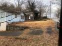 Light blue home with a covered front porch, driveway, and overgrown yard at 702 Emily Pl # 0, Atlanta, GA 30318