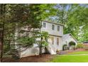 View of the home's exterior showcasing the two-story design and lush landscaping, enhancing its charm at 2240 Six Branches Dr, Roswell, GA 30076