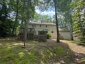 Rear view of home highlighting multiple decks, with access from the upper and lower levels, surrounded by trees at 4782 Donnegal Se Ct, Mableton, GA 30126
