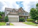 Charming two-story house with a two-car garage, stone detailing, and a neatly kept front yard at 558 Olympic Way, Acworth, GA 30102