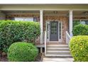 Inviting front entrance with a stylish gray door, brick surround, and manicured shrubbery at 558 Olympic Way, Acworth, GA 30102