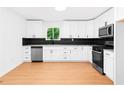 Modern kitchen with sleek white cabinets, stainless steel appliances, and black backsplash at 264 Howell Sw Ter, Atlanta, GA 30331
