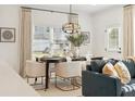 Dining room with modern chandelier, table set for dinner, and view to the backyard at 440 Carrera Ln, Acworth, GA 30102