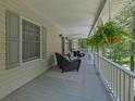 Inviting covered porch with comfortable seating, hanging ferns, and views of the surrounding trees at 2095 Honeysuckle Dr, Cumming, GA 30040