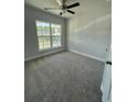 Carpeted bedroom features neutral walls and large window providing plenty of natural light at 4266 Mulberry Pass Ct, Hoschton, GA 30548