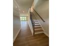 Bright foyer features wood flooring, staircase with iron balusters, and an open view to the living area at 4266 Mulberry Pass Ct, Hoschton, GA 30548