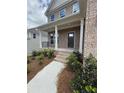Charming front entrance with brick steps and white pillars supporting the covered front porch at 4266 Mulberry Pass Ct, Hoschton, GA 30548