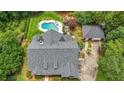 Aerial view of home with pool, detached garage, mature trees and lush landscaping providing privacy in a park-like setting at 750 Old Loganville Road Southwest, Loganville, GA 30052