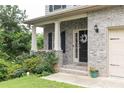 Inviting front porch with brick columns and lush landscaping at 3302 Bellingham Way, Lithia Springs, GA 30122