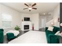 Bright living room featuring a fireplace, ceiling fan, and hardwood floors at 3302 Bellingham Way, Lithia Springs, GA 30122