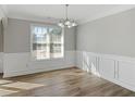 Dining room featuring modern chandelier, window, wood trim and neutral color palette at 341 Windermere Dr., Loganville, GA 30052
