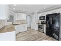 Kitchen with stainless steel appliances, stone countertops, white cabinetry, and hardwood flooring at 341 Windermere Dr., Loganville, GA 30052