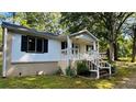 This single-story home has a beautiful front entrance, brick steps, and is surrounded by mature trees at 6197 Union Grove Rd, Lithia Springs, GA 30122