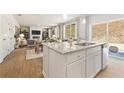 Gourmet kitchen with white cabinets, stainless steel appliances and a large island overlooking the living space at 8504 Polston Place Lot 145, Douglasville, GA 30134