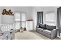 Well-lit bedroom with cozy sofa, crib, and neutral decor at 2330 Wood Creek Ct, Dacula, GA 30019