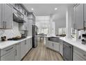 Modern gray kitchen featuring stainless steel appliances, white countertops, stylish backsplash and wood floors at 2330 Wood Creek Ct, Dacula, GA 30019