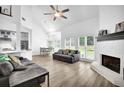 Bright, open living room featuring a fireplace, modern ceiling fan, and seamless flow to the kitchen and dining area at 2330 Wood Creek Ct, Dacula, GA 30019