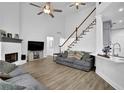 Spacious living room with a fireplace, staircase, wood floors, and open access to the kitchen area at 2330 Wood Creek Ct, Dacula, GA 30019