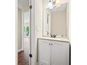 Compact half bath with a stylish vanity featuring a granite countertop and modern fixtures, providing convenience at 2431 Rosedale Creek Dr, Snellville, GA 30078