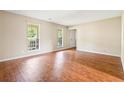 Bright living room featuring wood floors, two windows, and neutral paint, creating a welcoming atmosphere at 2431 Rosedale Creek Dr, Snellville, GA 30078