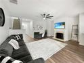 Bright living room features a fireplace, ceiling fan, wood floors, and cozy gray furnishings at 2964 Greyhawk Ln # 160, Cumming, GA 30040