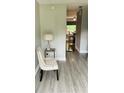View of the entryway with gray floors, a white chair, and lamp visible from the opened front door at 3233 Rockmill Dr, Ellenwood, GA 30294