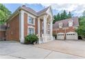 An inviting side view of a distinguished brick home, showcasing its architectural details and three-car garage at 5435 Chelsen Wood Dr, Duluth, GA 30097