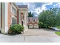 Side view of brick home with grand columns, complemented by an ample driveway and a three-car garage at 5435 Chelsen Wood Dr, Duluth, GA 30097