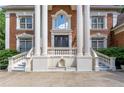 Up-close view of a stately brick home featuring classic columns, a grand entrance, and refined architectural details at 5435 Chelsen Wood Dr, Duluth, GA 30097