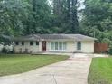 Charming one-story home with a well-manicured front lawn and a long concrete driveway at 1413 David Cir, Decatur, GA 30032