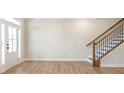 Open-concept living space with hardwood floors and staircase at 148 Palm St, Holly Springs, GA 30115