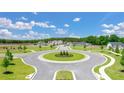 Planned community featuring a well-manicured roundabout surrounded by sidewalks, green lawns, and newly built homes at 1628 Palladian Dr, Lithonia, GA 30058