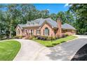 Elegant single-story brick home with circular drive, lush landscaping, and attached garage at 2065 Innsfail Dr, Snellville, GA 30078