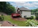 Expansive backyard with a red deck, offering outdoor space, complemented by mature trees at 655 Golden Meadows Ln, Suwanee, GA 30024