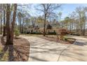 Stately home showcasing a long driveway, mature trees, and fountain, creating a welcoming curb appeal at 115 Flagstop Run, Fayetteville, GA 30215