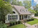 Inviting home with a covered front porch, stone accents, lush lawn, and a three car garage at 34 Johnston Nw Row, Cartersville, GA 30121