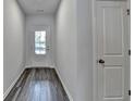 Inviting hallway with stylish dark-toned wood floors leads to a bright exterior door at 3968 Annsbury Court, Lilburn, GA 30047