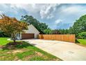 Exterior view of home featuring a garage, a wooden fence, and mature landscaping at 858 Pates Creek Rd, Stockbridge, GA 30281