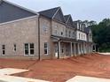 Spacious gray brick townhome with white trim, large windows, and a covered front porch at 3232 Cyrus Creek Dr, Kennesaw, GA 30152